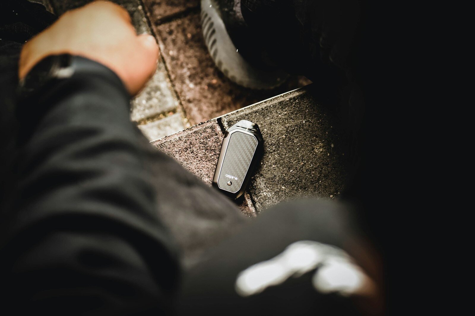 black and gray electric cigarette near left person's hand