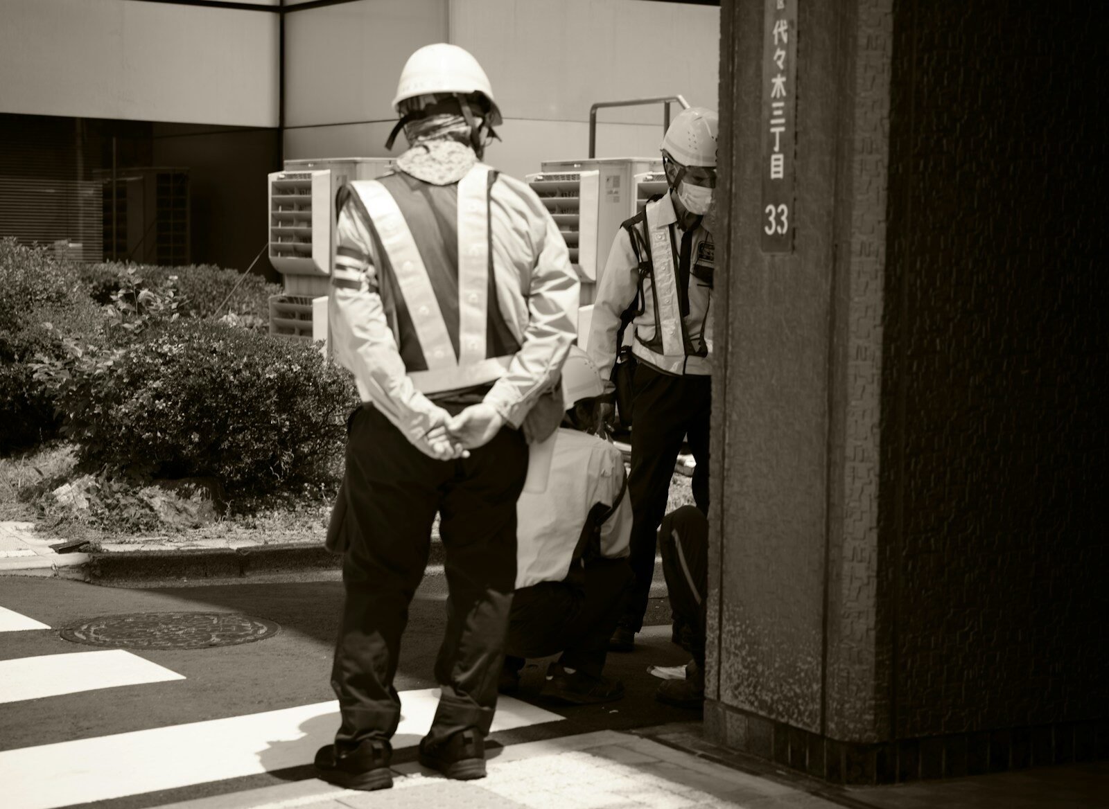 Two men wearing reflective vests and hard hats outside