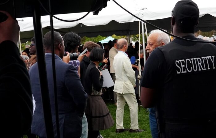 Security guard watches over a gathering under a tent