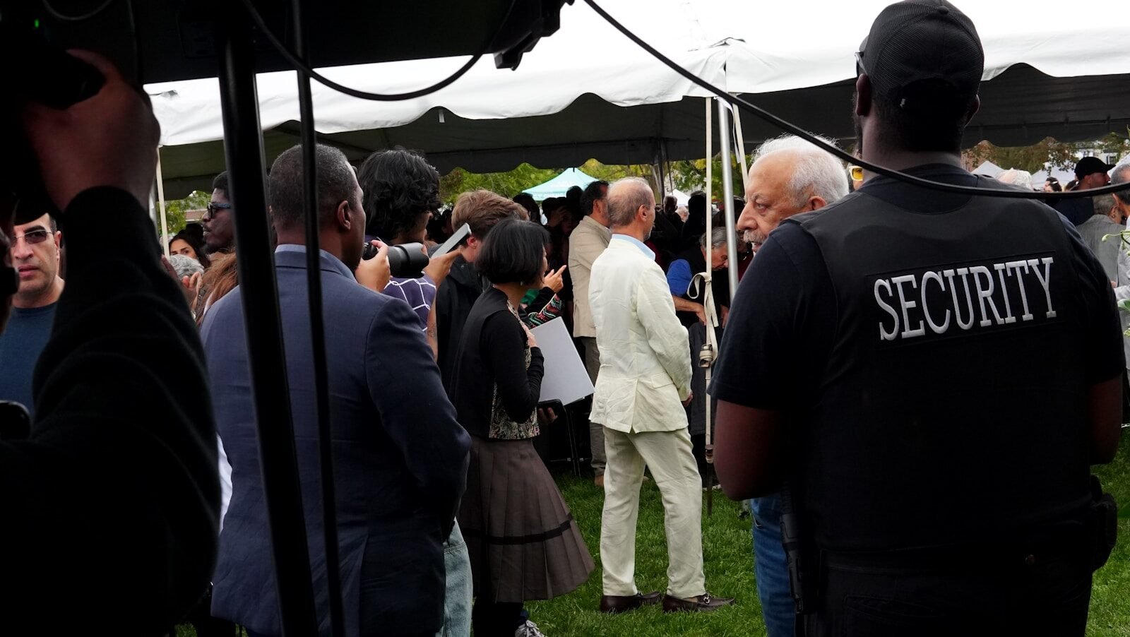 Security guard watches over a gathering under a tent