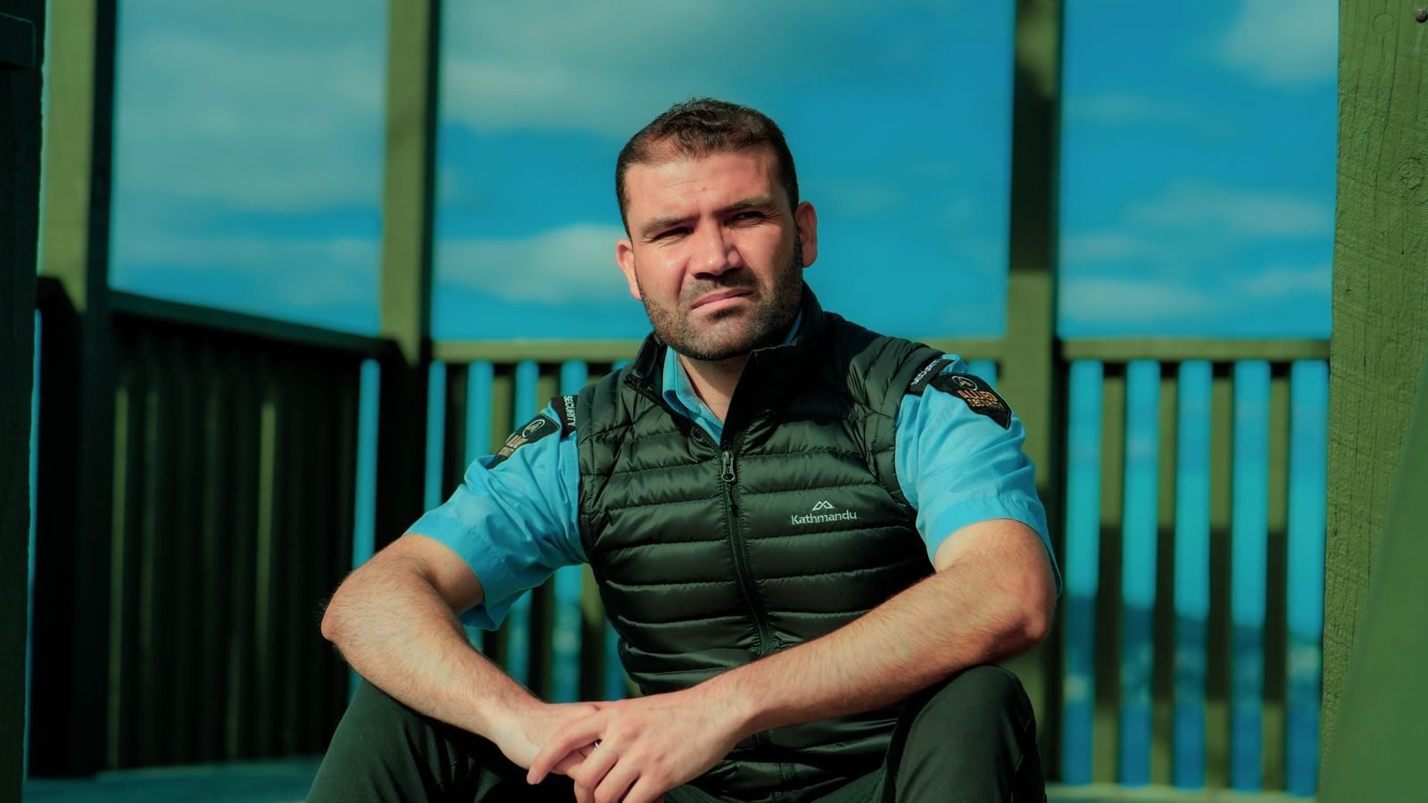 Security guard sitting outdoors in uniform. Ideal for security and occupation themes.