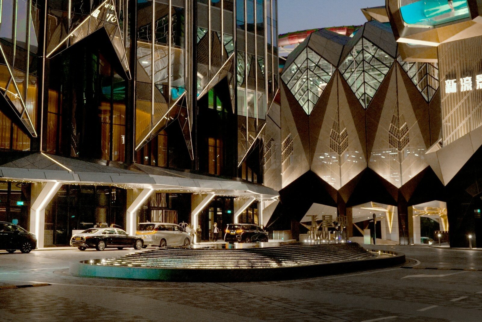 Modern architectural building with cars outside at entrance