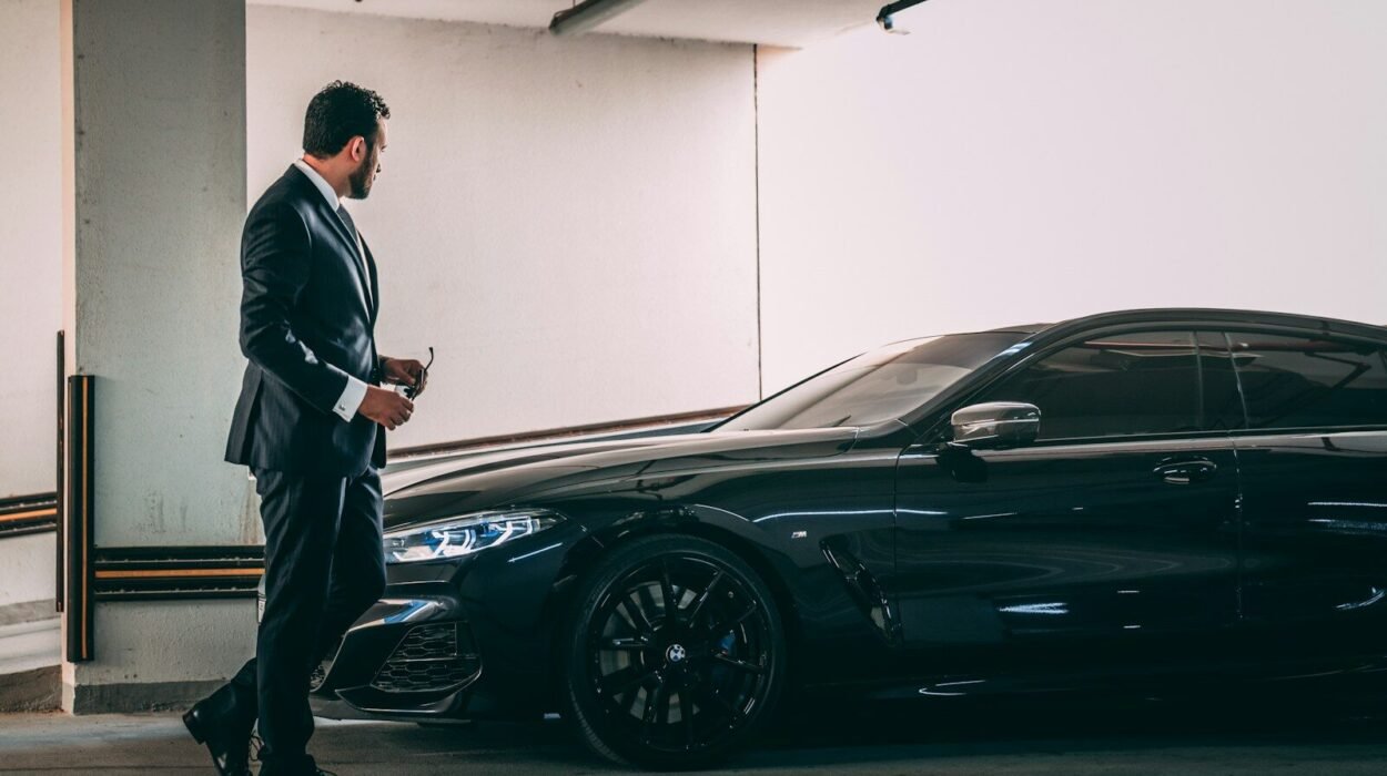 a man in a suit standing next to a car