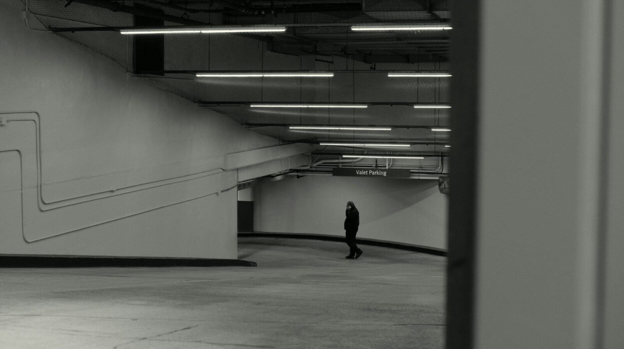 A lone person stands in a dimly lit underground walkway