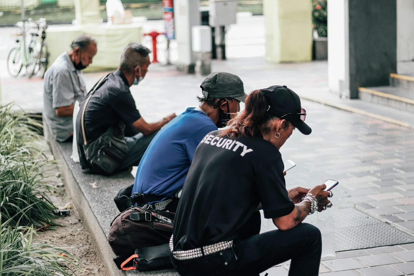a group of people sitting on the side of a street