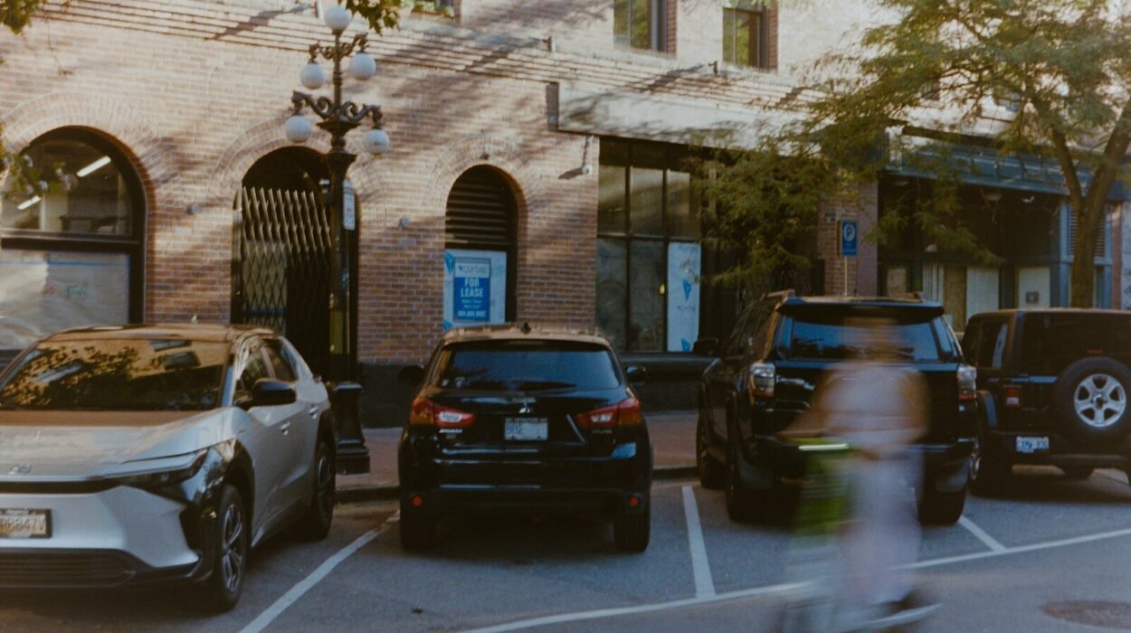 Cars parked on street with blurry person on scooter